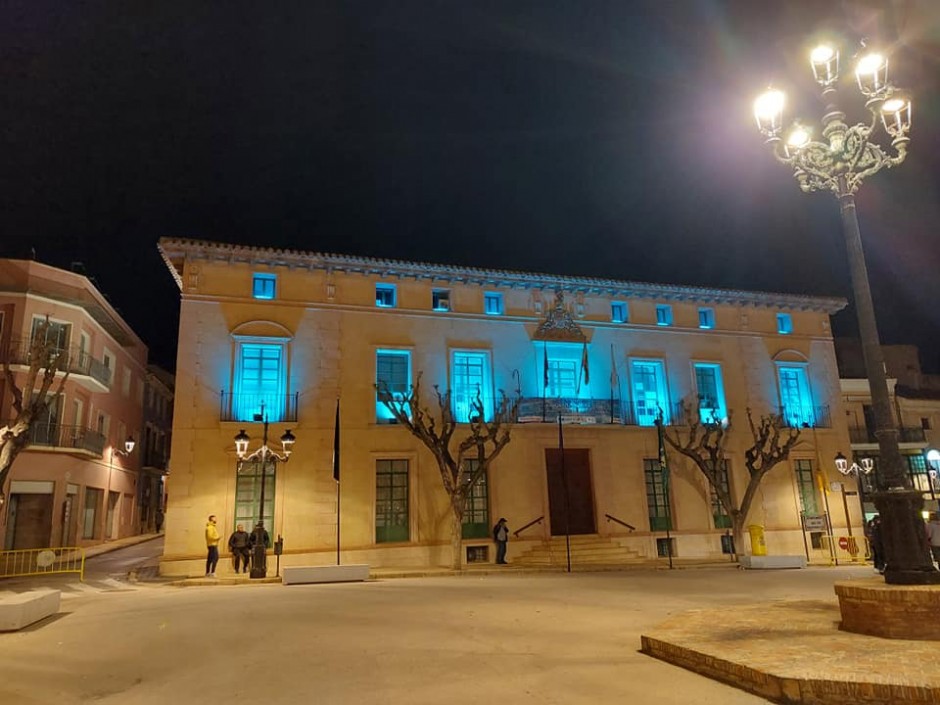 La fachada principal del Ayuntamiento de Totana se ilumina de color turquesa  con motivo del Día Mundial de las Lipodistrofias