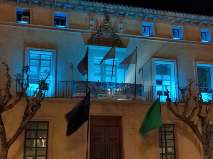 El ayuntamiento de Totana se suma al Manifiesto del Día Mundial de las Lipodistrofias colocando una pancarta conmemorativa e iluminando de azul turquesa la fachada consistorial