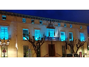 La fachada principal del Ayuntamiento de Totana se ilumina de color azul turquesa como muestra de apoyo al Día Mundial de las Lipodistrofias